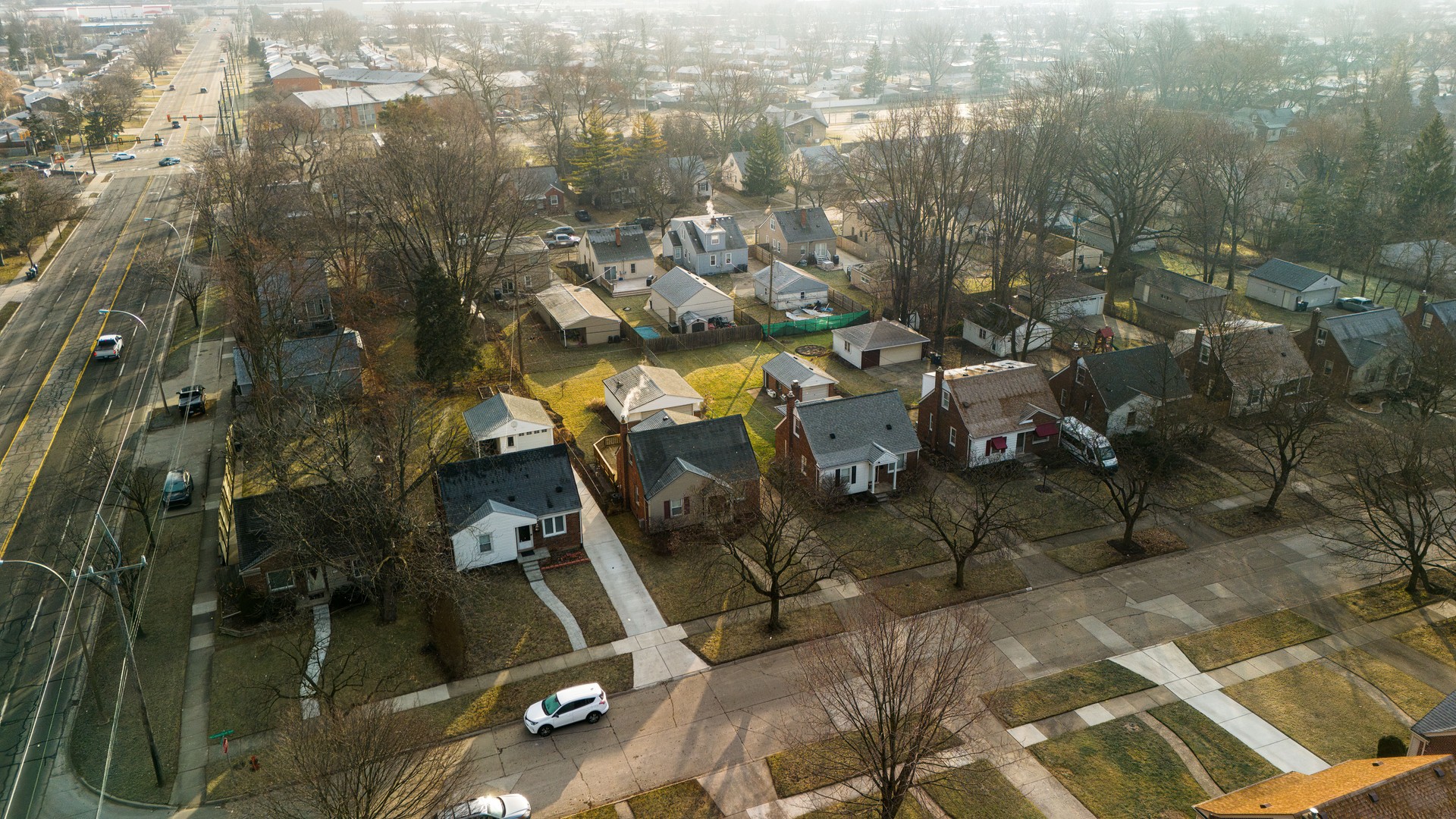 Sunny spring Royal Oak neighborhood in Michigan: car traffic moves through the road to horizon